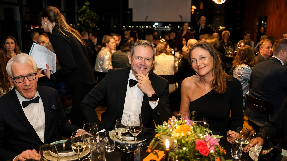 Well-dressed gala guests posing together at a candlelit dinner